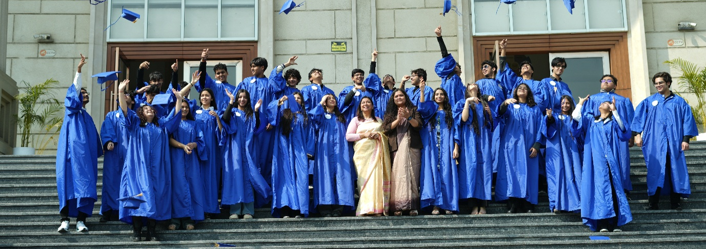 HXLS Noida Grade 10 students in graduation gowns tossing their caps on the school steps